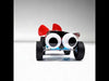 DIY Aerodynamic Trolley science project kit featuring a red propeller fan, motor, wheels, and googly eyes mounted on a blue chassis for demonstrating airflow and motion.